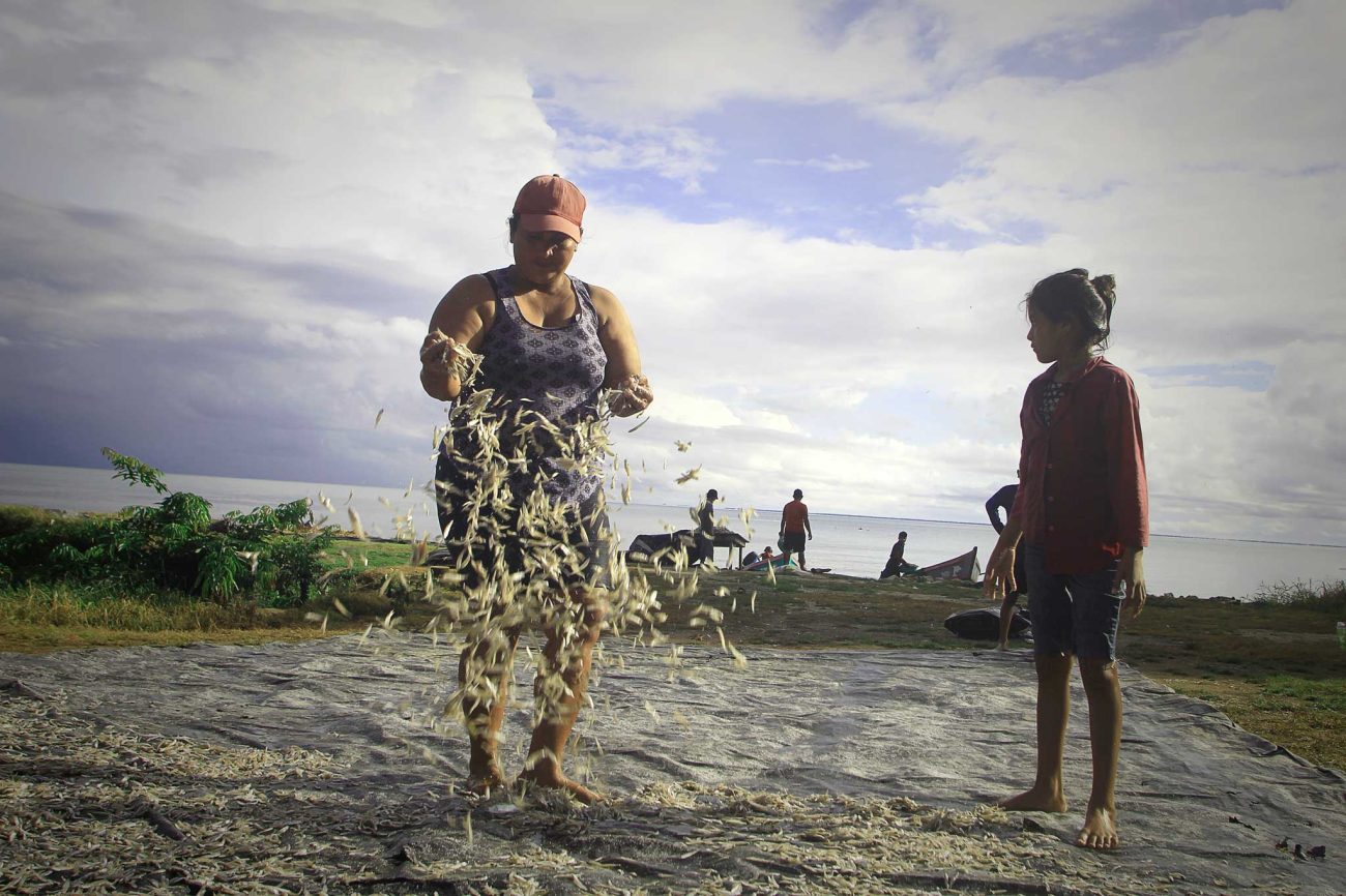 Zoila Guerrero descarga el producto pescado, ya salado, y lo extiende sobre un trozo de plástico negro para secarlo al sol y luego ponerlo a la venta. Foto: Jorge Rodríguez